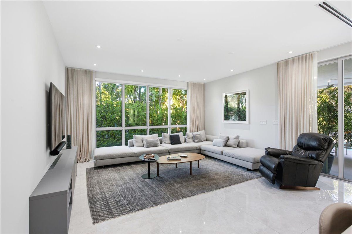 Family room with a large sectional and floor-to-ceiling garden windows