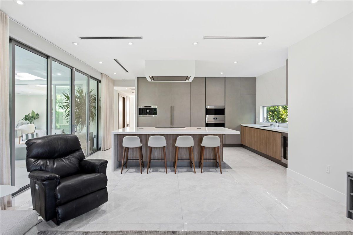 Italian-designed kitchen with a waterfall quartz island and four counter stools