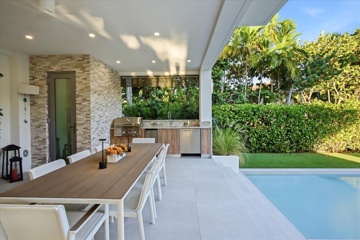 Summer kitchen with grill and refrigeration beside the pool